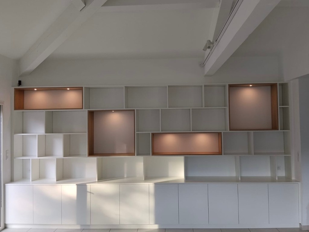 Agencement intérieur bibliothèque sur mesure avec rangements muraux et niches, réalisé par Les Sens du Bois 13.
Egger