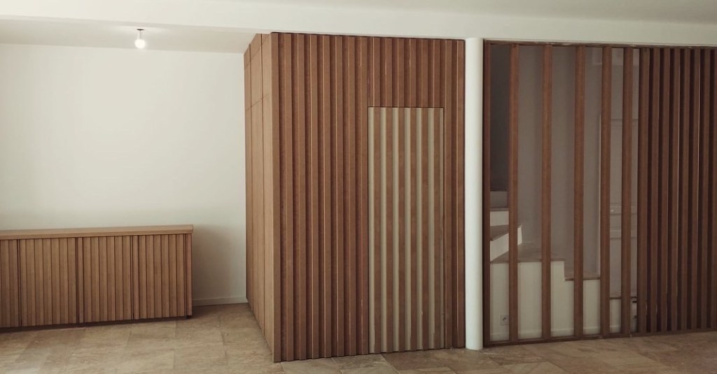 Claustra et rangement sur mesure en bois avec tasseaux verticaux.