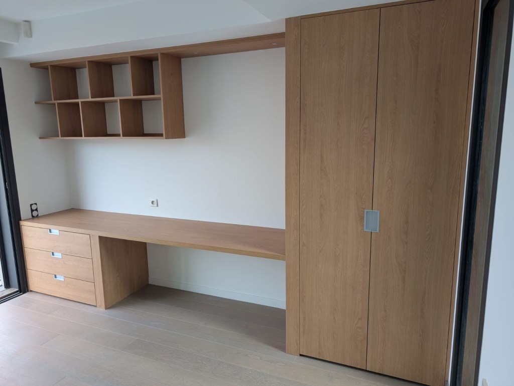 Bureau sur mesure en bois avec étagères murales, tiroirs et placard intégré.