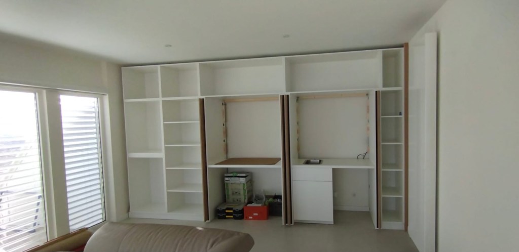 Agencement de cuisine sur mesure avec colonnes de rangement et niches ouvertes portes escamotables .