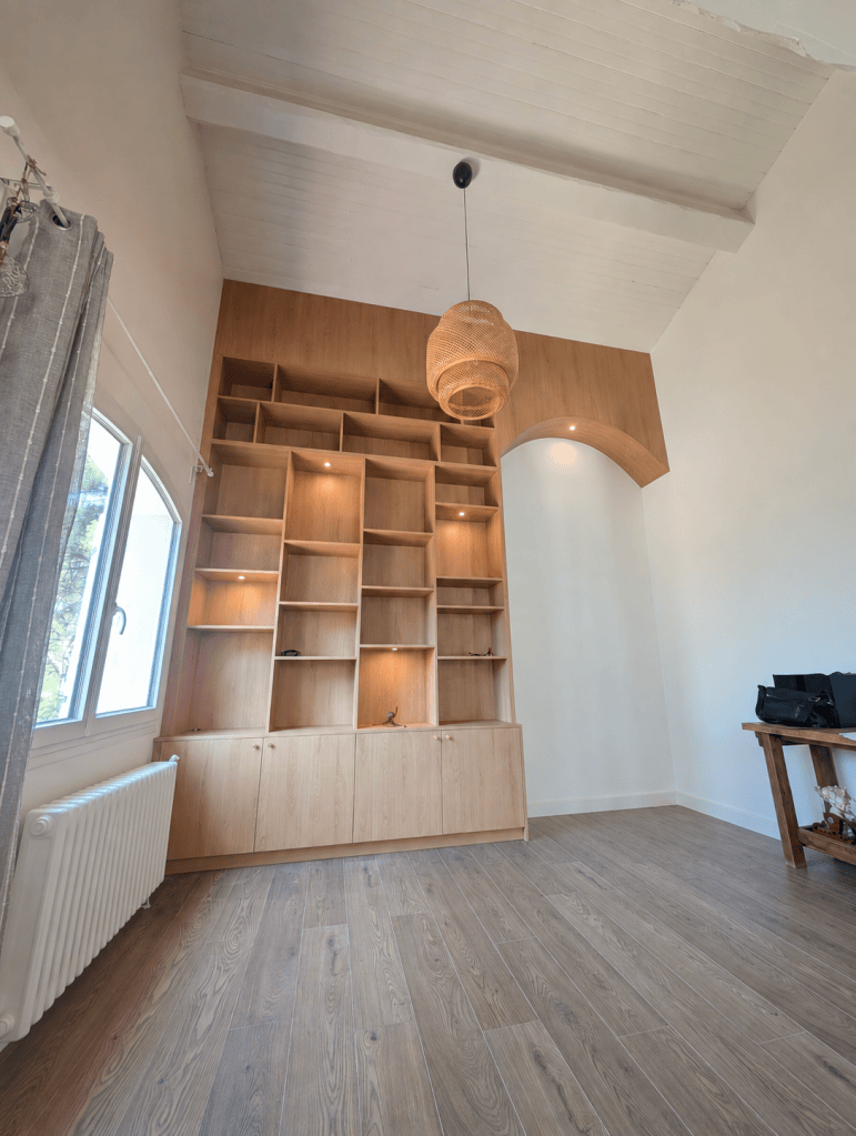 Agencement mural sur mesure en bois clair avec rangements et niches, réalisé par Les Sens du Bois 13.