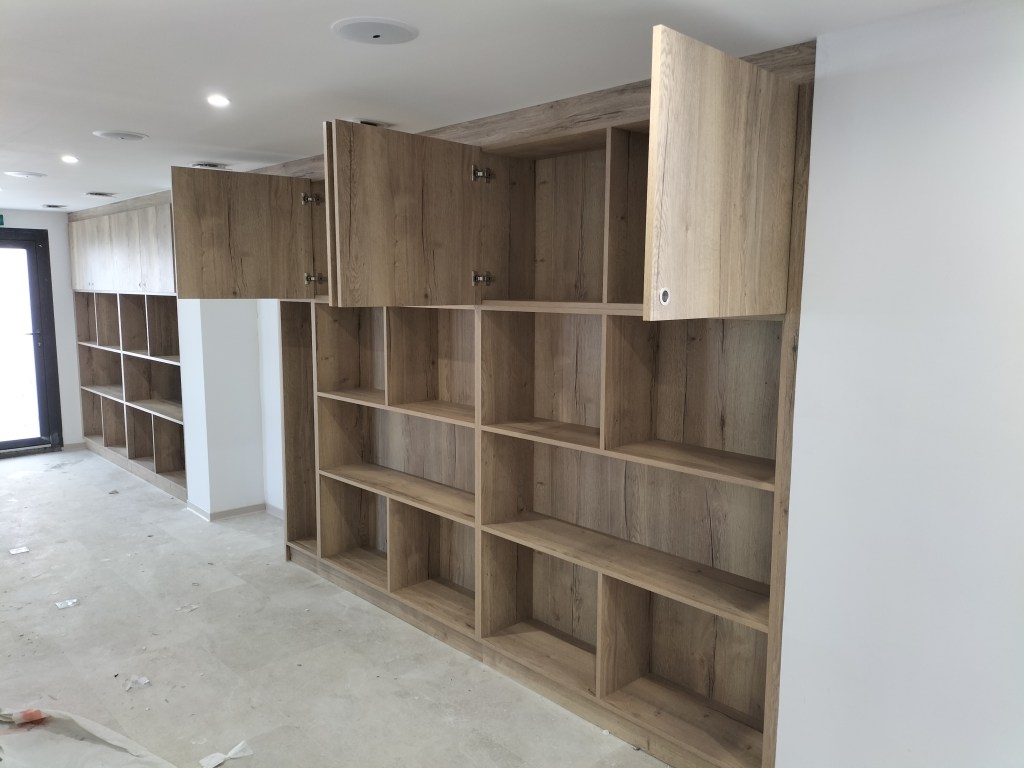 Dressing ouvert en bois avec étagères et rangements réalisés sur mesure.