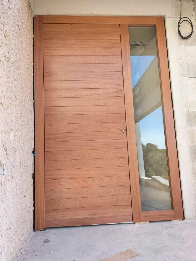 Porte d’entrée sur mesure en bois avec vitrage latéral. bois sipo