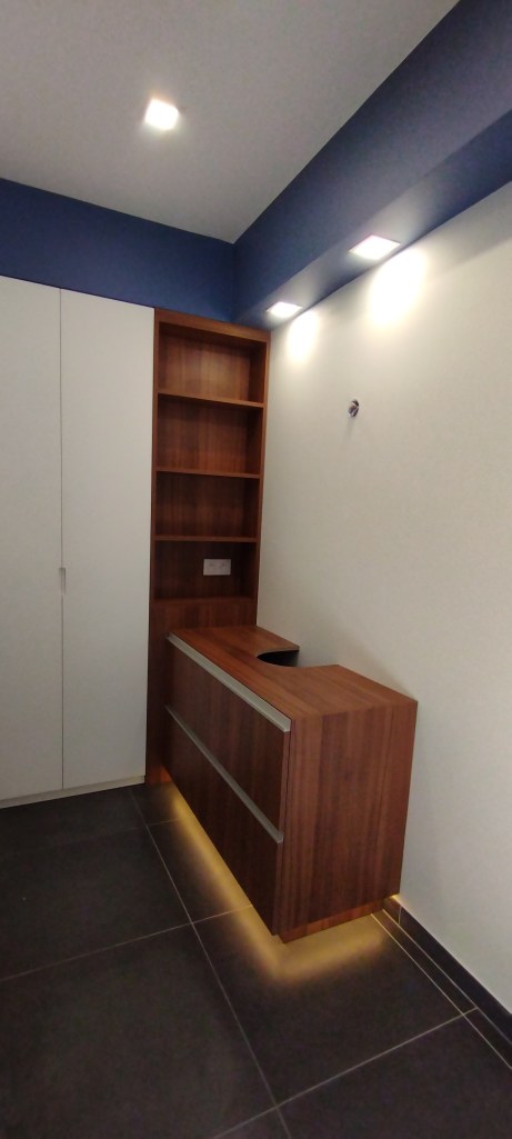 Meuble  vasque sur mesure en bois foncé avec étagères et éclairage intégré.